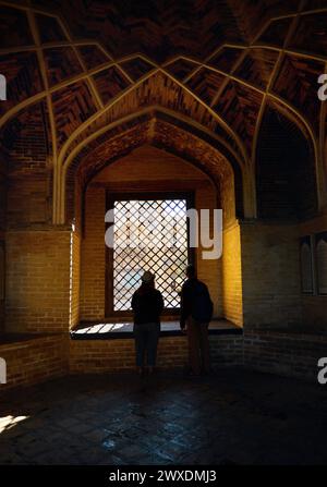 Wunderschöner Blick auf das Wahrzeichen von Madrasah und die Touristensilhouette der Menschen vor dem Fenster zum Innenhof in der Altstadt von Bokhara, Usbekistan Stockfoto