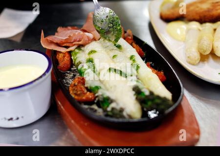 Klaistow, Deutschland. 30. März 2024. Ein klassisches Spargelgericht wird in der Küche des Restaurants im Spargelhof Klaistow serviert. Quelle: Carsten Koall/dpa/Alamy Live News Stockfoto