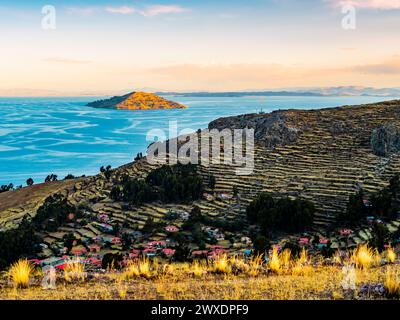 Beeindruckende Landschaft auf der Insel Amantani bei Sonnenuntergang mit gestuften Terrassenfeldern, Titicacasee, Puno Region, Peru Stockfoto