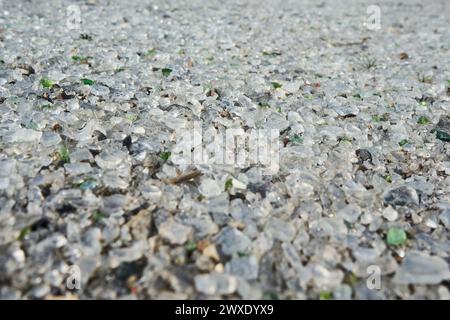 Seitenansicht von vielen kleinen Stücken zerbrochenem transparentem und grünem Glas. Texturhintergrund. Verlassene Glasfabrik. Stockfoto