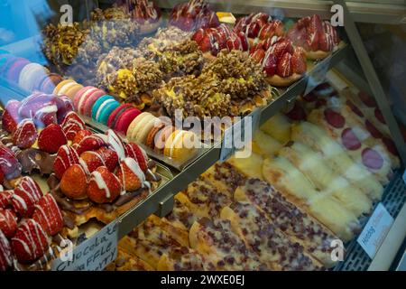 Frische, köstliche süße Kuchen gibt es im Laden hinter einem Glasfenster Stockfoto