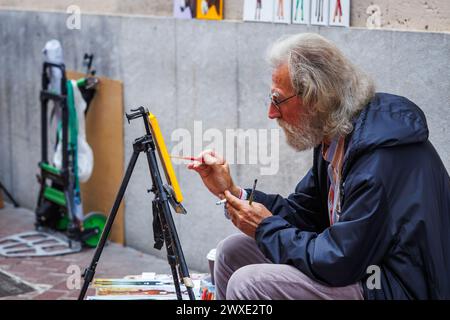 Palma de Mallorca, Spanien - 29. April 2023: Straßenmalerei auf Leinwand auf einer Stadtstraße. Senior man genießt einen freischaffenden künstlerischen Lebensstil Stockfoto