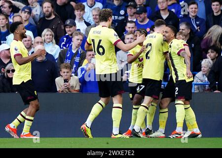 Josh Cullen (Hidden) von Burnley feiert das erste Tor ihrer Mannschaft im Spiel mit seinen Teamkollegen während des Premier League-Spiels in Stamford Bridge, London. Bilddatum: Samstag, 30. März 2024. Stockfoto