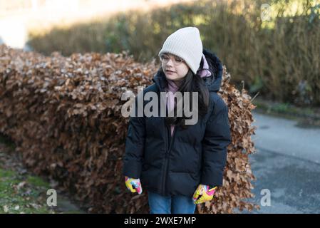 Outdoor Lifestyle Porträt einer jungen schönen glücklichen und hübschen asiatischen Chinesin in Wintermantel und Hut, die auf der Straße spazieren Stockfoto
