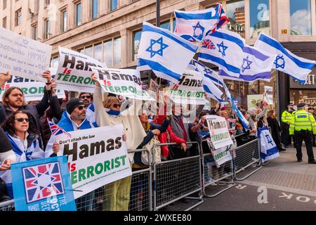 Somerset House, London, Großbritannien. 30. März 2024. Bei einem formellen Gegenprotest hält ein Kollektiv besorgter britischer Einwohner und Bürger aller Glaubensrichtungen, die sagen „genug ist genug“ und sich vereint gegen den wachsenden Hass auf den Straßen Londons wehren, Zeichen „Hamas ist Terrorist“ und fördert die Regierungspolitik; „Hamas sind eine Terrorgruppe“. Der in London ansässige Iraner Niyak Ghorbani wurde kürzlich von der Metropolitan Police verhaftet, während er angegriffen wurde, weil er bei einem Pro-Palästina-marsch dasselbe Zeichen trug. Foto: Amanda Rose/Alamy Live News Stockfoto