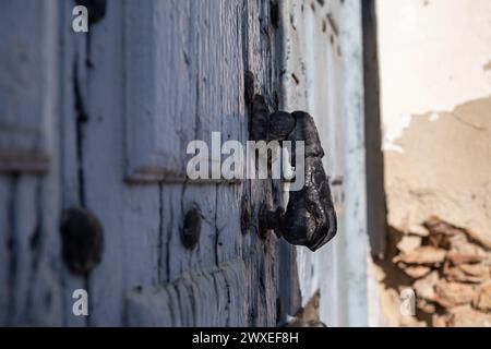 Nahaufnahme des Klopfers einer alten blau lackierten Holztür mit rostigen Eisenbeschlägen und Schlossansicht des Klopfers eines alten blau lackierten Holzes Stockfoto