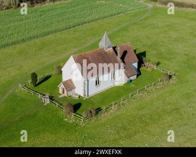 St. Huberts die Kirche auf dem Hügel von oben. Sonniger Frühlingstag in Idsworth Hampshire. Blick nach unten zum Vordereingang und zur rechten Seite. Stockfoto