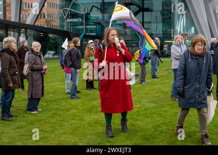 Amsterdam, Niederlande, 30.03.2024, Aktivist mit lgbt-Progress-Stolz-Flagge während der Protestaktion von Extinction Rebellion Klimaaktivisten Stockfoto