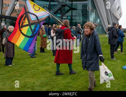 Amsterdam, Niederlande, 30.03.2024, Aktivist mit lgbt-Progress-Stolz-Flagge während der Protestaktion von Extinction Rebellion Klimaaktivisten Stockfoto