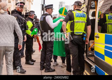 Somerset House, London, Großbritannien. 30. März 2024. Ein Anti-Israel-Mann, der als Priester in den Farben der Hisbollah gekleidet ist, wird von der Metropolitan Police verhaftet, nachdem er aggressiv versucht hat, Menschen des Pro-Israel/Anti-Hamas-Gegenprotests anzugreifen, die Zeichen mit der Aufschrift „Hamas ist Terrorist“ hielten Foto von Amanda Rose/Alamy Live News Stockfoto