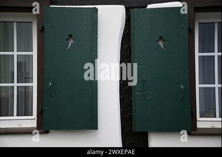 Antikes Landhausfenster mit zypressengrünen Holzläden an einer weiß getünchten Wand im malerischen Dorf Châtenois im Elsass, Frankreich. Stockfoto