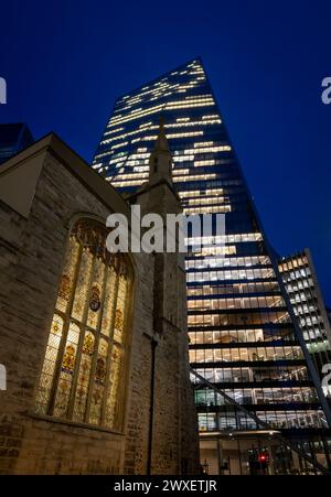 London, Großbritannien: St Andrew Undershaft Church auf der St Mary Axe in der City of London bei Nacht mit dem Scalpel-Gebäude dahinter. Stockfoto