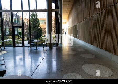 Flur und Flur in einem modernen Gebäude mit großen Glasfenstern und Sitzecke. Stockfoto