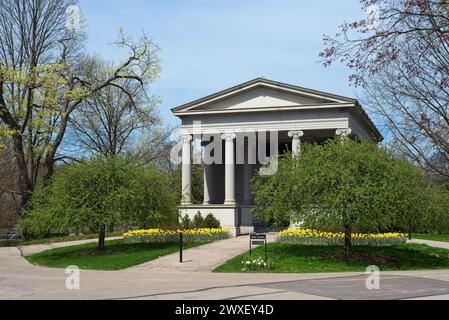 Wade Chapel, ein neoklassizistisches Bauwerk, ist ein häufig besuchter Ort auf Cleveland Lake View Cemetery, der hier mit Narzissen vor dem Friedhof zu sehen ist. Stockfoto