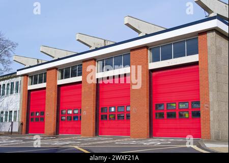 Gebäude der Feuerwehr-Station mit roten Rollladentüren Stockfoto