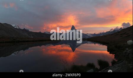 Panorama des Sonnenuntergangs mit dramatischem alpenglow am Hochgebirgssee Stellisee mit dem berühmten Alpengipfel Matterhorn, Zermatt, Schweiz Stockfoto