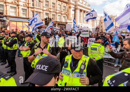 Somerset House, London, Großbritannien. 30. März 2024. Reihen von Metropolitan Police Polizisten bilden eine Verteidigungsbarriere, um die Pro-Israel/Anti-Hamas-Gegenprotestierenden vor dem Pro-Palästina-marsch durch das Zentrum Londons zu schützen. Die Gegenprotestierenden sind ein Kollektiv von besorgten britischen Einwohnern und Bürgern aller Glaubensrichtungen, die sagen "genug ist genug" und stehen vereint gegen den wachsenden Hass auf den Straßen Londons. Foto: Amanda Rose/Alamy Live News Stockfoto