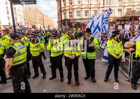 Somerset House, London, Großbritannien. 30. März 2024. Reihen von Metropolitan Police Polizisten bilden eine Verteidigungsbarriere, um die Pro-Israel/Anti-Hamas-Gegenprotestierenden vor dem Pro-Palästina-marsch durch das Zentrum Londons zu schützen. Die Gegenprotestierenden sind ein Kollektiv von besorgten britischen Einwohnern und Bürgern aller Glaubensrichtungen, die sagen "genug ist genug" und stehen vereint gegen den wachsenden Hass auf den Straßen Londons. Foto: Amanda Rose/Alamy Live News Stockfoto