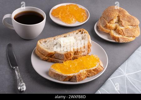 Sandwiches mit Aprikosenmarmelade und einer Tasse Kaffee auf grauem Hintergrund Stockfoto
