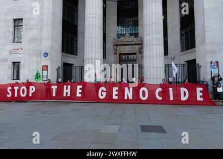 London, Großbritannien. 30. März 2024. Ein großes Banner vor dem Bush House in Aldwych erklärt "Stop the Genocide", während Zehntausende palästinensischer Anhänger durch das Zentrum Londons zum Trafalgar Square marschieren und zu einem Waffenstillstand und einem Ende der Unterstützung Großbritanniens und der USA für die Belagerung Israels aufrufen. Bombardierung und Invasion des Gazastreifens nach einem Angriff von Hamas-Militanten. Quelle: Ron Fassbender/Alamy Live News Stockfoto