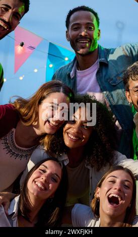 Porträt von aufgeregten jungen Menschen, die sich bei Partynächten für ein Foto ausgeben Stockfoto