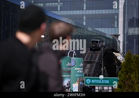 New York, USA. 30. März 2024. Bei der Agility-Demonstration am 2. Tag der New York International Auto Show 2024 im Jacob Javits Convention Center, New York, NY, 30. März 2024, beobachten die Leute, wie Jeeps eine abgewinkelte Rampe hinaufsteigen. (Foto: Anthony Behar/SIPA USA) Credit: SIPA USA/Alamy Live News Stockfoto