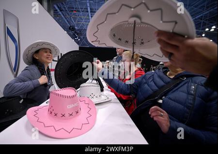 New York, USA. 30. März 2024. Am zweiten Tag der New York International Auto Show 2024 im Jacob Javits Convention Center, New York, New York, NY, 30. März 2024, stehen die Leute an, um farbige Cowboyhüte im Buick Pavillon zu bekommen. (Foto: Anthony Behar/SIPA USA) Credit: SIPA USA/Alamy Live News Stockfoto