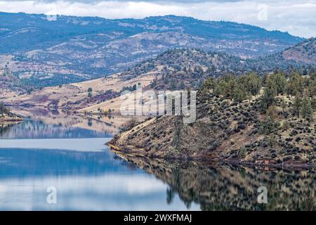 Die umliegenden Hügel und Wälder spiegeln sich im Stausee am Iron Gate Dam in der Nähe von Hornbrook in Kalifornien, USA, wider Stockfoto