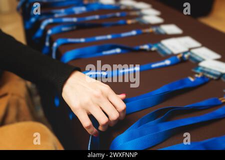 Prozess des Einchecking bei einer Konferenz Kongress Forum Veranstaltung, Anmeldung Tisch, Besucher und Teilnehmer erhalten einen Namensschild und Eingang Handgelenk Stockfoto