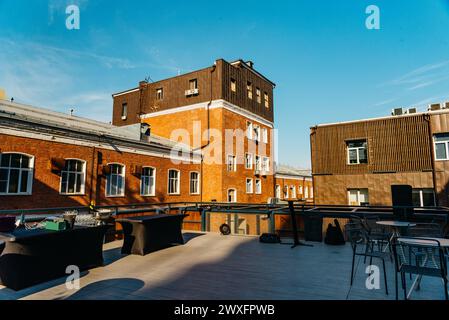 Eine moderne Veranda auf dem Dach eines renovierten Gebäudes verbindet historische Backsteinarchitektur mit neuem Stadtdesign unter freiem Himmel. Stockfoto