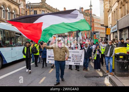 Leeds, Großbritannien. 30. MÄRZ 2024. Pro-Palestine-ProtestantInnen wehen so große palästinensische Flagge, wie Demonstranten durch das Zentrum von Leeds auf der Eberspur marschieren. Die Route begann und endete in der Leeds Art Gallery, wobei sie die Boar Lane und The Headrow hinunterfuhr, ohne dass es Ärger gab. Credit Milo Chandler/Alamy Live News Stockfoto