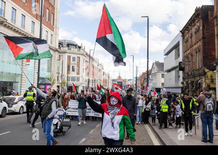 Leeds, Großbritannien. 30. MÄRZ 2024. Pro-palästinensische Demonstranten, darunter ein Demonstrant mit anonymer Maske, marschieren die Headrow entlang auf dem Weg durch das Zentrum von Leeds. Die Route begann und endete in der Leeds Art Gallery, wobei sie die Boar Lane und The Headrow hinunterfuhr, ohne dass es Ärger gab. Credit Milo Chandler/Alamy Live News Stockfoto