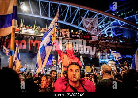 Tel Aviv, Israel. 30. März 2024. Ein israelisches Kind schwenkt die israelische Flagge während eines Protestes am Samstag, dem 30 2024. März in Tel Aviv. Am Samstag waren Zehntausende in ganz Israel zum größten Protest seit dem 7. Oktober gegen die aktuelle Regierung unter Premierminister Benjamin Netanjahu und verlangten einen Geiselvertrag mit der Hamas. Quelle: SOPA Images Limited/Alamy Live News Stockfoto