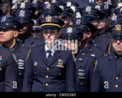 New York, USA. 30. März 2024. NYPD-Offiziere stehen am Ende der Prozession zur Beerdigung des gefallenen NYPD-Offiziers Jonathan Diller mit Hunderten von Polizisten, die vor der St. standen, fest Rosa von Lima Toman Katholische Kirche. Laut Polizeiberichten führten Officer Diller, 31 Jahre alt, und sein Partner einen Verkehrsstopp für ein illegal geparktes Auto in Far Rockaway durch. Während der Begegnung warf eine Person im Fahrzeug eine Schusswaffe und richtete sie auf die Offiziere, was zu einem Austausch von Schüssen führte. Quelle: SOPA Images Limited/Alamy Live News Stockfoto