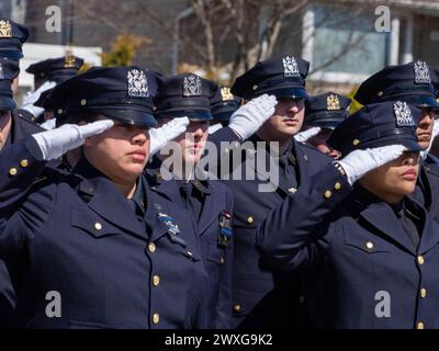 New York, USA. 30. März 2024. NYPD-Offiziere grüßen, wenn der Leichenwagen vorbeigeht. Die Beerdigung für den gefallenen NYPD-Offizier Jonathan Diller wurde mit Hunderten Polizisten vor der St. Rosa von Lima Toman Katholische Kirche. Laut Polizeiberichten führten Officer Diller, 31 Jahre alt, und sein Partner einen Verkehrsstopp für ein illegal geparktes Auto in Far Rockaway durch. Während der Begegnung warf eine Person im Fahrzeug eine Schusswaffe und richtete sie auf die Offiziere, was zu einem Austausch von Schüssen führte. Quelle: SOPA Images Limited/Alamy Live News Stockfoto