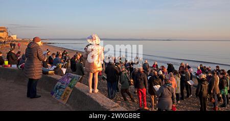 Portobello, Edinburgh, Schottland, Großbritannien. 31. März 2024. Atemberaubender Sonnenaufgang im britischen Sommer an der schottischen Küste sowie Ostersonntag. Im Bild: Mitglieder der Pfarrkirche Portobello Joppa versammeln sich bei Sonnenaufgang, um Lieder zu singen und am Ostermorgen willkommen zu heißen. Quelle: Arch White/Alamy Live News. Stockfoto