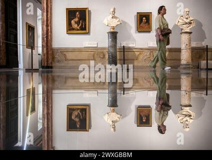 Peking, Italien. März 2024. Ein Besucher spaziert im Palazzo Barberini in Rom, Italien, 29. März 2024. Zwei berühmte Kunstsammlungen in Rom verschmelzen vom 29. März bis Juni 30 zu einer Ausstellung mit dem Titel „Raphael, Tizian und Rubens, Meisterwerke von der Galleria Borghese bis zum Palazzo Barberini“, in der Meisterwerke aus der Galleria Borghese ausgestellt werden, während letzterer Renovierungsarbeiten unterzogen wird. Quelle: Li Jing/Xinhua/Alamy Live News Stockfoto