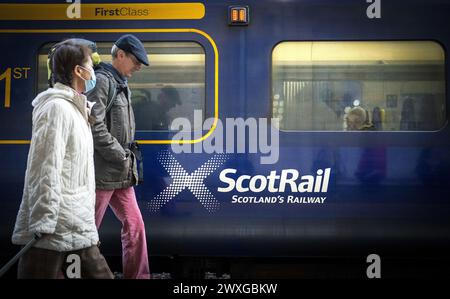 Dateifoto vom 05/22 von Pendlern, die an einem ScotRail-Zug an Edinburghs Waverley Station vorbeilaufen. In den zwei Jahren seit der Verstaatlichung von ScotRail wurden fast 27.500 Eisenbahndienste eingestellt, wie die Zahlen zeigen. Ausgabedatum: Sonntag, 31. März 2024. Stockfoto