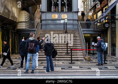 Wenige Touristen vor dem Eingang zum Santa Justa Lift am frühen Wintermorgen. Lissabon, Portugal. Februar 2024. Stockfoto