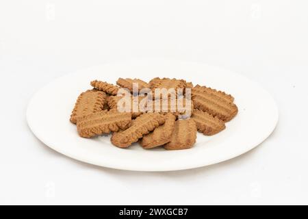 Dunkelbraune zuckersüße Kekse in Teller auf isoliertem weißem Hintergrund Stockfoto