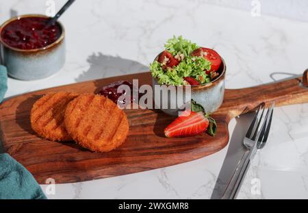 Eine Portion frisch gebratenen Camembert-Käse mit Preiselbeersauce und einem Salat Stockfoto