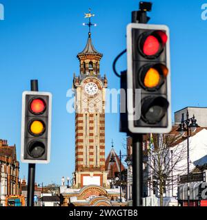 Epsom Surrey, Großbritannien, März 30 2024, Rote und gelbe Ampeln mit Uhrturm im Hintergrund und No People Stockfoto