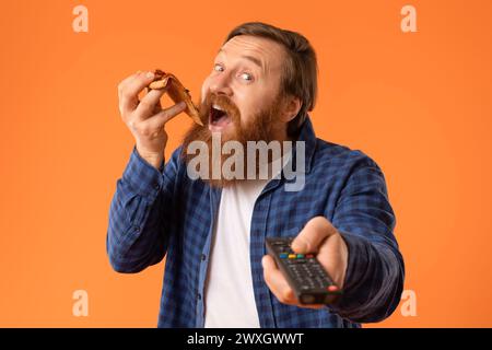 Rothaariger bärtiger Mann genießt Pizzapunkte Fernbedienung, Nahaufnahme Porträt Stockfoto