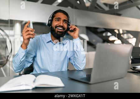 Lächelnder Mann mit Headset, der im Büro arbeitet Stockfoto