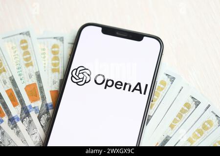 KIEW, UKRAINE - 17. MÄRZ 2024 OpenAI-Logo auf dem iPhone-Display mit vielen hundert Dollar-Scheinen. Engine für künstliche Intelligenz Stockfoto