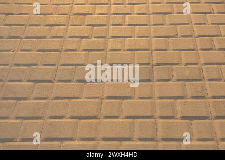 Stein gelbes Mosaik Stadt Straßenbodenfliese in sonnigem Sonnenuntergang hellen Hintergrund Textur. Stockfoto