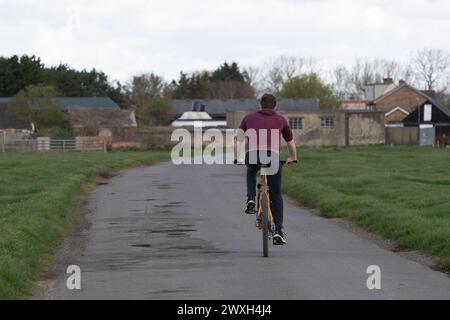 Dorney, Buckinghamshire, Großbritannien. 30. März 2024. Ein Mann radelt auf einer Landstraße in Dorney, Buckinghamshire. Quelle: Maureen McLean/Alamy Live News Stockfoto