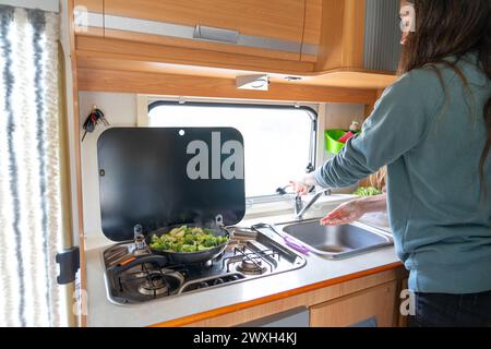 Frau kocht in einem Wohnmobil Stockfoto