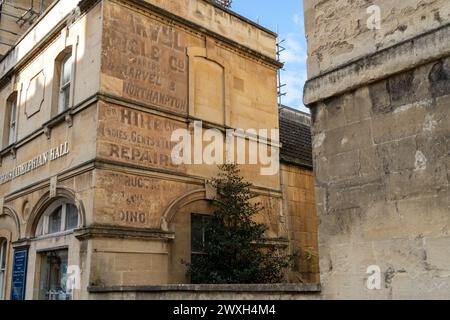 Ein Geisterschild - alte Werbung an der Seite einer Mauer in Bath, Somerset, Großbritannien. Stockfoto