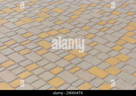 Grau Gelb Farbe Diagonale Muster Linien Streifen Pflastersteinboden Oberfläche Straße Straße Stadt Textur Hintergrund Fliese. Stockfoto